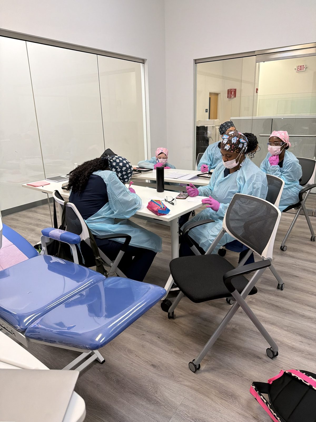 Dental assistant students in gowns and gloves during a Saturday clinical